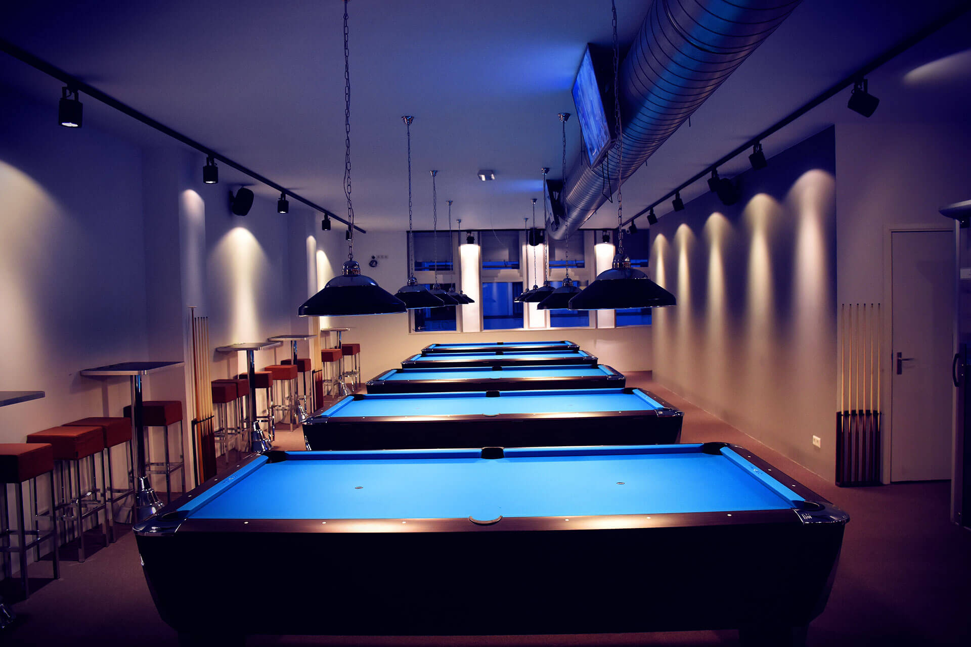 A row of lit pool tables